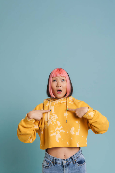 Asian shocked girl with pink hair and piercing pointing finger at herself isolated over blue background - Fotoğraf, Görsel
