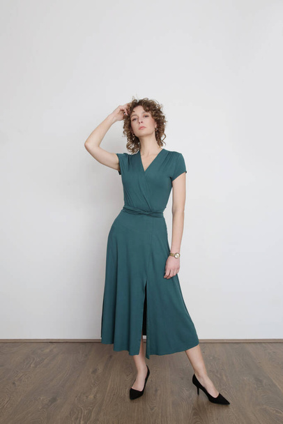 Serie of studio photos of young female model in green viscose wrap dress. - Photo, Image