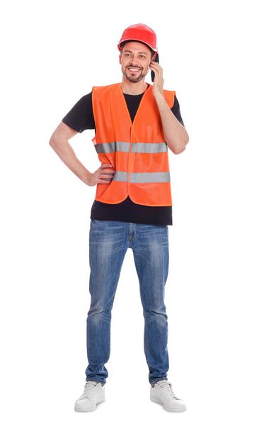 Male industrial engineer in uniform talking on phone against white background - Foto, Imagem