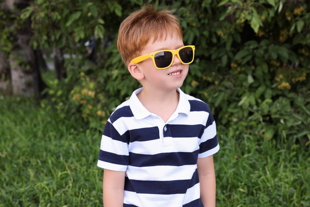 Lindo niño pequeño con gafas de sol en el parque - Foto, imagen