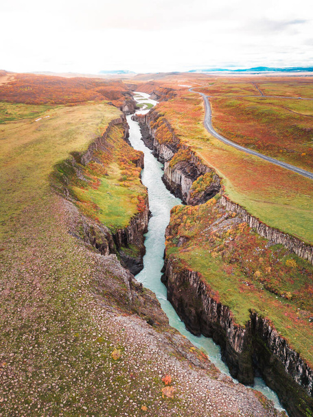 Enorme hermosa cascada Gullfoss, famoso hito en Islandia. Río espumoso mientras cae por la cascada, turista caminando por, mirando a la cascada desde un punto de vista. Foto de alta calidad - Foto, Imagen