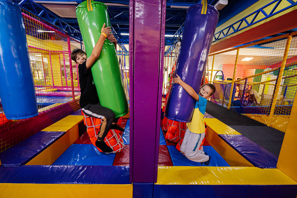 Playing at indoor play center playground, brothers in punching bags. - Foto, imagen
