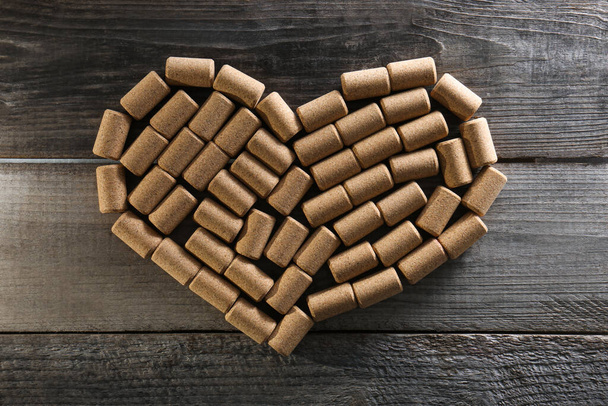 Heart made of wine bottle corks on wooden table, top view - Foto, Imagem