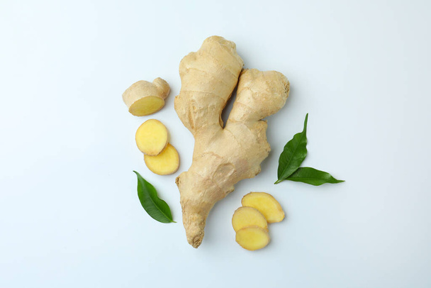 Fresh ginger with green leaves on white background, flat lay - Zdjęcie, obraz