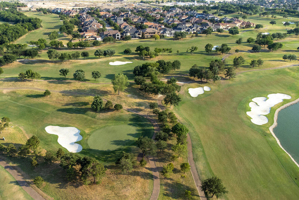 Aerial overview of luxury villas located around green zone and golf playground in the summertime. - Photo, image