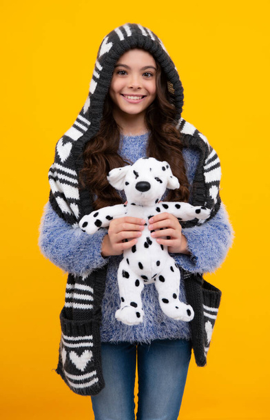 Teen girl in casual clothes hold soft toy for birthday on yellow background. Kid spending time with her toys. Autumn or winter kids wear. - Fotoğraf, Görsel