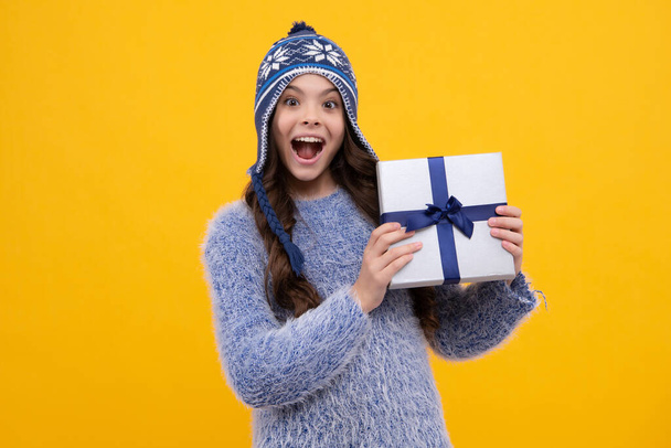 Emotional teenager child hold gift on birthday. Funny kid girl holding gift boxes celebrating happy New Year or Christmas. Excited teenager girl - Photo, Image