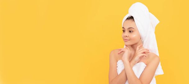 Girl with healthy skin, facial treatment, smiling teen girl in shower towel with cream on face. Cosmetics and skin care for teenager child, poster design. Beauty kid girl banner with copy space - Photo, Image