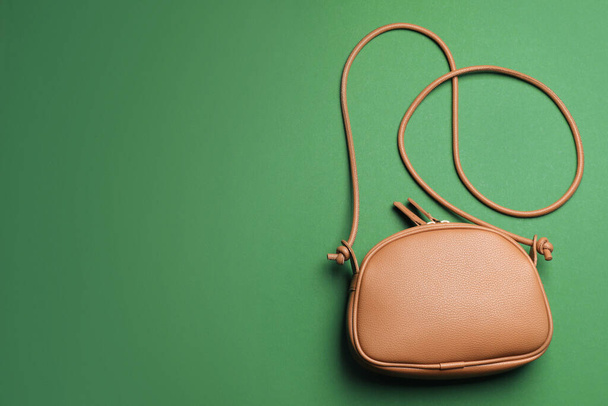 Stylish woman's bag on green background, top view. Space for text - Foto, immagini
