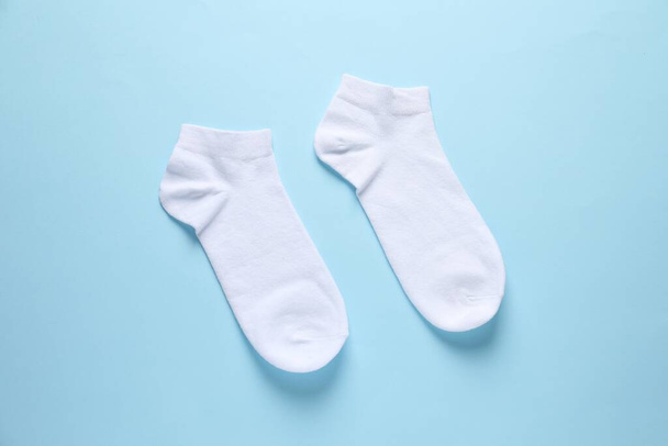 Pair of white socks on light blue background, flat lay - Foto, Imagen