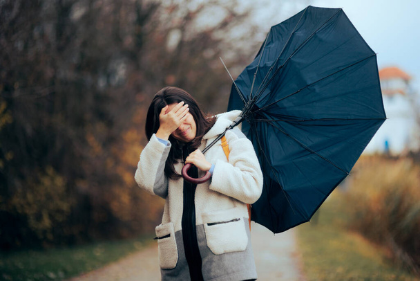 Frau mit zerbrochenem Regenschirm läuft im Sturm - Foto, Bild