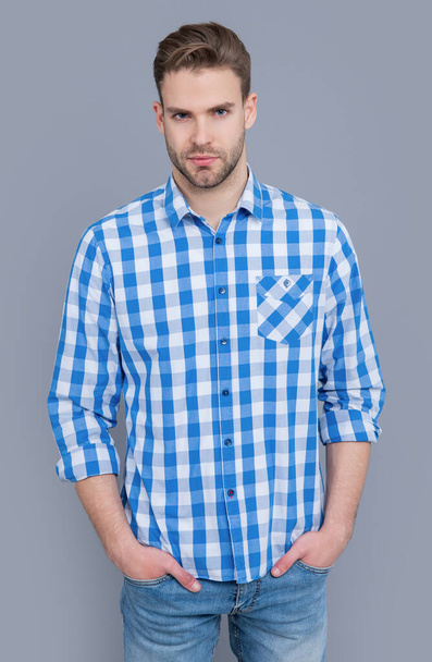 young guy in checkered shirt isolated on grey background. guy in casual style. studio shot of guy. caucasian guy having stubble. - Zdjęcie, obraz