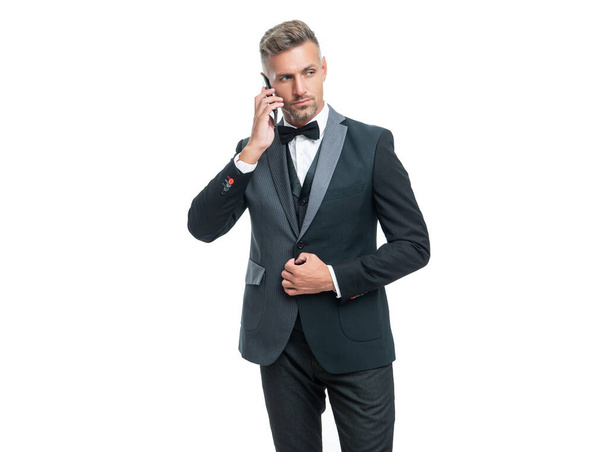 businessman in tux speaking on smartphone isolated on white background. - Fotoğraf, Görsel