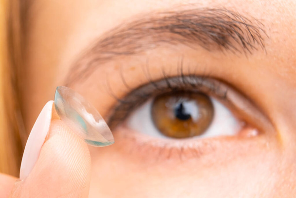 Görüşü iyileştirmek için kontakt lens, dişi kahverengi göze yakın.  - Fotoğraf, Görsel
