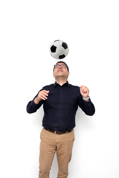 Дорослий латиноамериканець грає з футбольним м "ячем, дуже схвильований тим, що він побачить гру і захоче виграти свою команду. - Фото, зображення