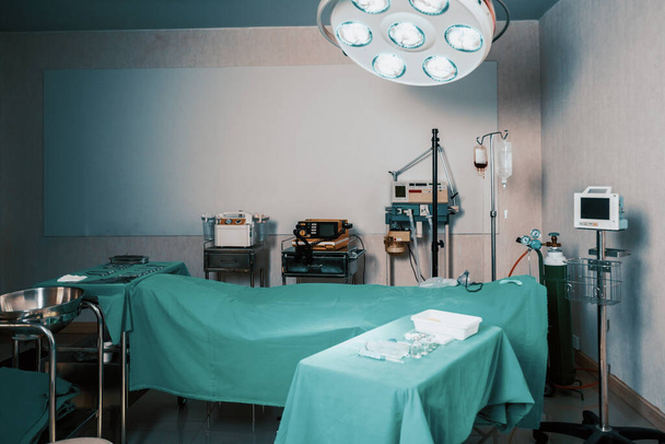 Sala de operação estéril no hospital exibe conjuntos de equipamentos cirúrgicos médicos dispostos sobre a mesa. Sala de cirurgia com ferramentas cirúrgicas de fundo para fins médicos. - Foto, Imagem