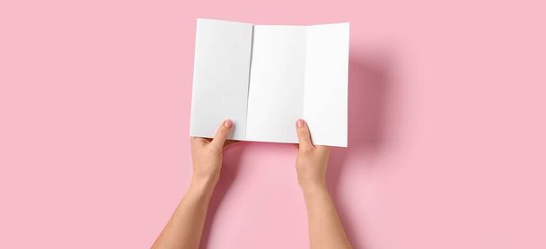 Hands with blank brochure on pink background - Photo, Image