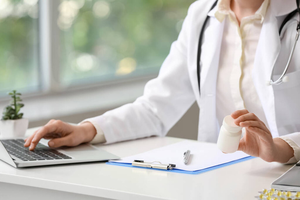 Žena lékař s vitamíny pomocí notebooku na klinice, detailní záběr - Fotografie, Obrázek