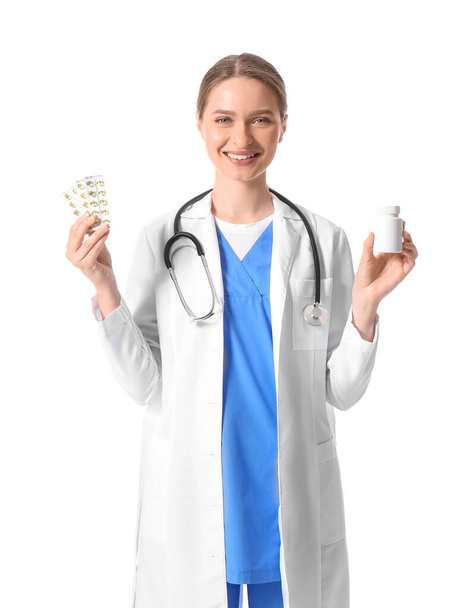 Médico femenino con vitaminas sobre fondo blanco - Foto, Imagen