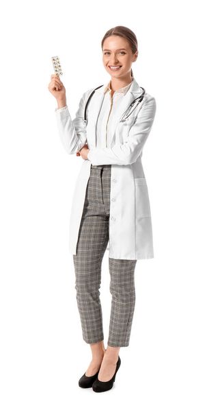 Médico femenino con vitaminas sobre fondo blanco - Foto, imagen