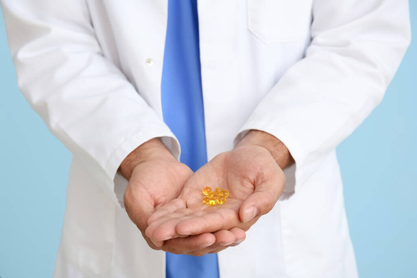 Medico maschile con vitamine su sfondo blu, primo piano - Foto, immagini