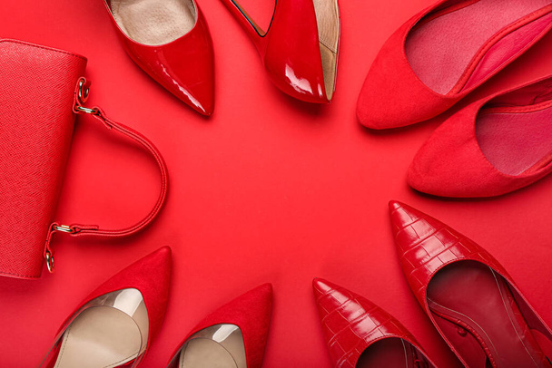 Frame made of stylish heels and bag on red background - Foto, imagen