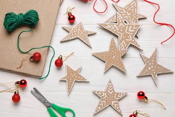 Cardboard stars with Christmas balls on white wooden background - Foto, Imagem
