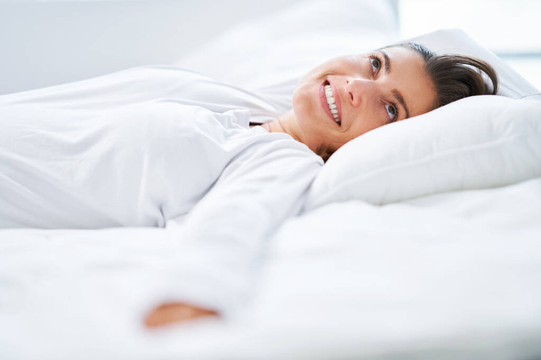 Hezká žena v posteli, relaxující nebo cvičící jógu. Kvalitní fotografie - Fotografie, Obrázek