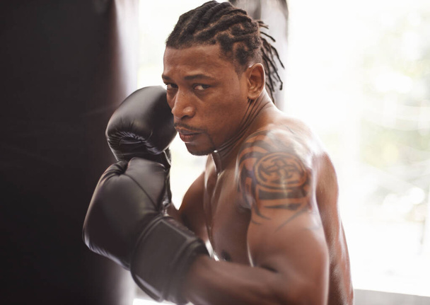 Стреляй изо всех сил. Портрет молодого боксера, практикующего в тренажерном зале - Фото, изображение