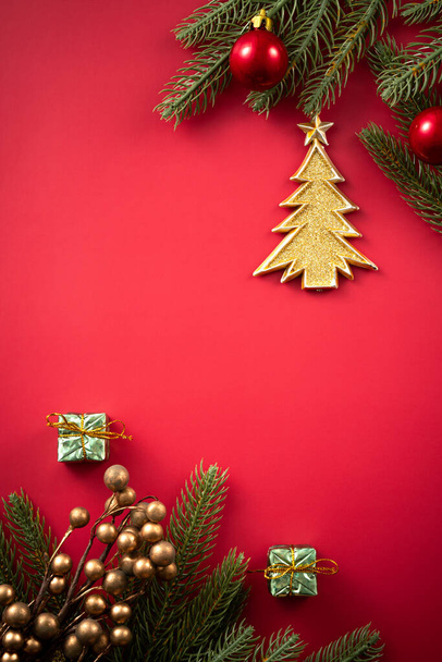 Christmas background design concept, holiday decoration ornament composition with Christmas tree branch, star with copy space isolated on red table. - Foto, immagini