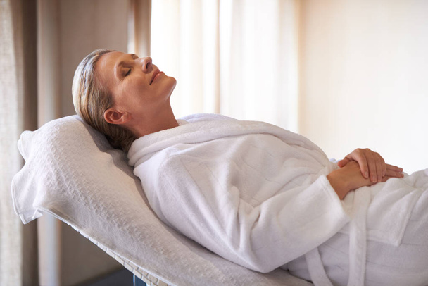 Enjoying a day of pamperinng. a woman in a day spa relaxing on a massage table - Photo, Image