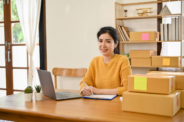 Гарний жіночий бізнесмен азіатського походження сидить за своїм столом, працюючи над своїм бізнесом. Концепція бізнес-бізнесу. - Фото, зображення