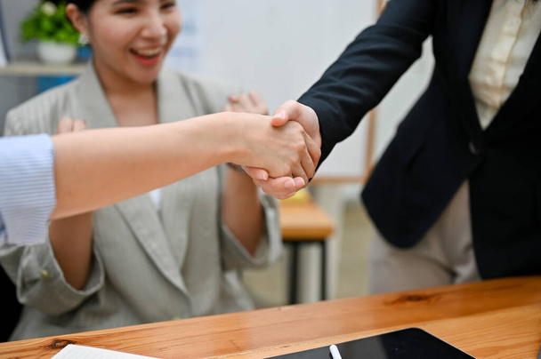 Обрізаний знімок, дві бізнес-леді тремтять руками після успіху в їх діловій зустрічі переговорів. бізнес-пропозиції, вітання, вітання, ласкаво просимо, командна робота
. - Фото, зображення