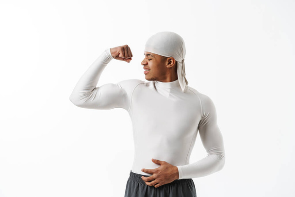Young hispanic sportsman wearing showing his bicep at camera isolated over white background - Foto, Bild