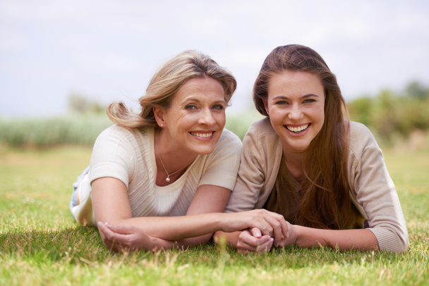 Quality time in the outdoors. A mother and daughter lying side by side in the outdoors - Foto, Bild