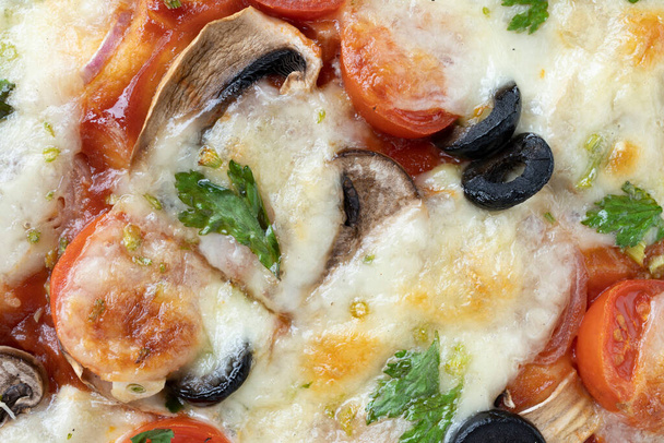 Macro shot de pizza italiana con mozzarella y tomates cherry, champiñones y cebollas rojas, especias, ketchup y pimentón. Cocina italiana. - Foto, imagen