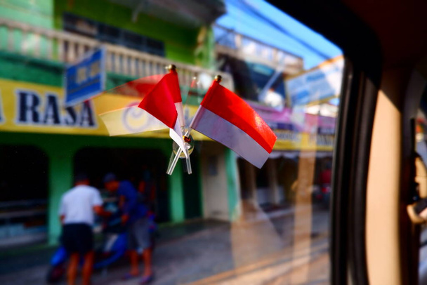 Η κόκκινη και άσπρη σημαία για την ημέρα ανεξαρτησίας της Ινδονησίας εγκαθίσταται στο παράθυρο του αυτοκινήτου - Φωτογραφία, εικόνα