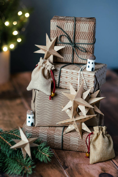 Joululahjat, pieni puuvilla laukku, tähdet, tammenterho mökkejä puinen tausta lähellä joulukuusi. DIY orgaaninen kestävä koristelu. Nolla jätettä ja muoviton käsite. Olen pahoillani. Laadukas kuva - Valokuva, kuva