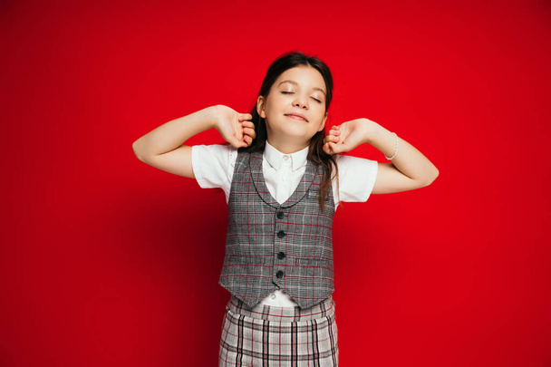 pleased girl with closed eyes stretching arms isolated on red, banner  - Fotoğraf, Görsel