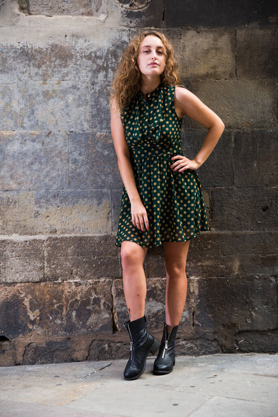 Cheerful young girl standing near brick wall at street in Barcelona, Spain - Photo, Image