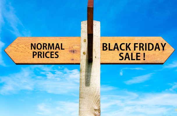 Dřevěné cedule s dvěma naproti šipkami na jasně modré obloze, normální ceny oproti černý pátek prodej zprávy, prodej rámcové obrázek - Fotografie, Obrázek
