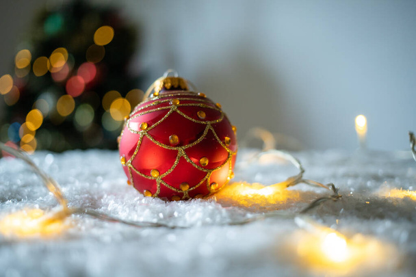 Красная рождественская безделушка в снегу
 - Фото, изображение