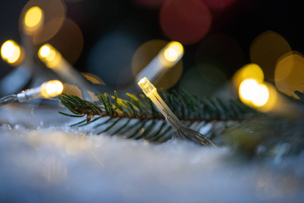 雪の中のクリスマスストリングライト - 写真・画像