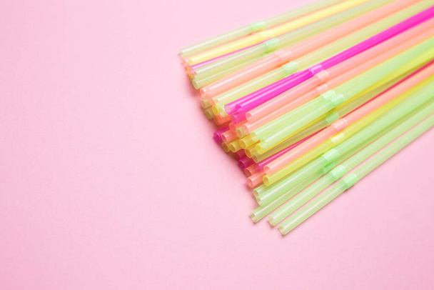 Colored cocktail straws close-up on a pink isolated background. - Zdjęcie, obraz