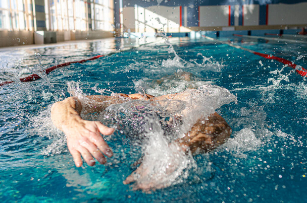 Swimmer in the pool. A male athlete is engaged in swimming in a sports pool. - Foto, Imagem