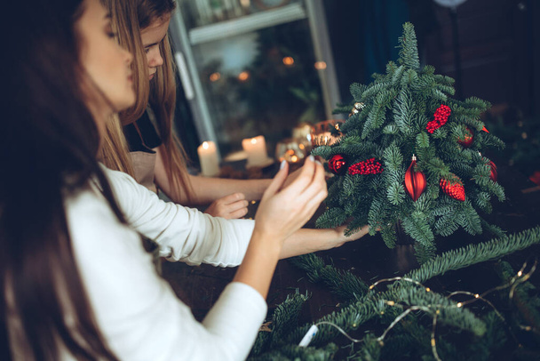 A woman makes a Christmas tree with her own hands. High quality photo - Zdjęcie, obraz