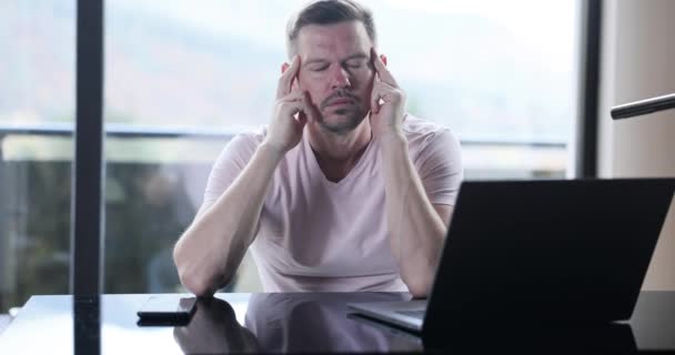 Genç adam evde çalışırken migrenden muzdarip. Baş ağrısı ve açık hava işleri - Video, Çekim