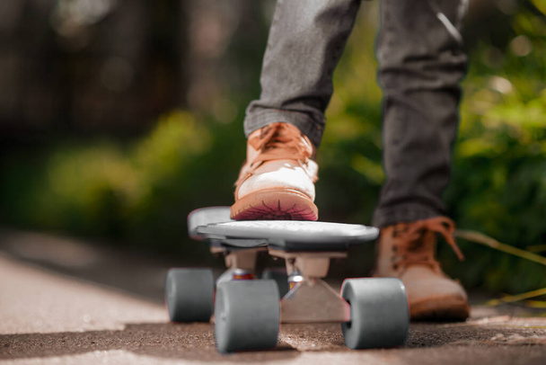 Skateboard. Close up picture of a kids hand holding a skateboard - Zdjęcie, obraz