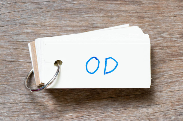 Flash card z odręcznym napisem w słowie OD (skrót od overdraft) na tle drewna - Zdjęcie, obraz