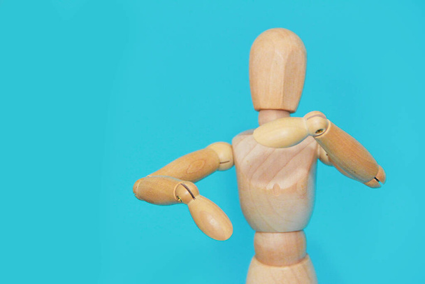 žlutá dřevěná figurína gesta s rukama na modrém pozadí - Fotografie, Obrázek